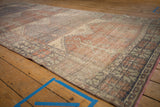 Worn texture of vintage Oushak rug with faded prayer panels and geometric palmette border.