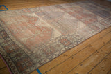 Distressed vintage Oushak runner showing mostly even wear, faded brick, and geometric plant motifs.