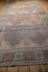 Distressed vintage Oushak runner with worn pale brick and blue germinating plant motifs.