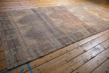 Corner of distressed Oushak runner, showing worn pile, geometric border, and original side cord.