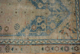Visible distressed knot heads and indigo blue geometric patterns on vintage Anatolian rug.