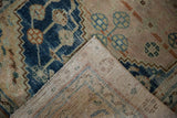 Distressed vintage Anatolian rug showing indigo, beige pile, and woven foundation.