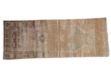 Vintage distressed Oushak runner with faded asymmetric prayer design in muted beige, mauve, and green hues.
