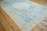 Angled detail of a distressed Oushak carpet highlighting its even wear and low pile texture.