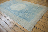 Vintage Turkish Oushak carpet with an evenly worn low pile and softened blue and sand colors.