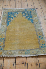 Distressed vintage Oushak rug, gold prayer field, sky blue floral mehrab, even wear.