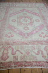 Worn pile of a vintage Oushak rug showing pale aubergine pinwheel floral motifs.