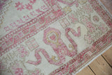 Distressed vintage Oushak rug with pale aubergine pinwheel florals and wide cloudband border.