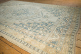 Distressed vintage Oushak carpet's stepped medallion with muted ivory, slate blue, and gold floral patterns.