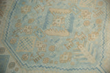 Distressed pile of a vintage Oushak rug, with powder blue and beige plant patterns.