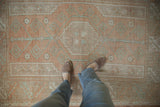 Distressed vintage Melas rug with terra cotta, seafoam, and ivory geometric patterns.