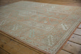 Faded terra cotta and seafoam geometric patterns on a distressed vintage Melas rug.