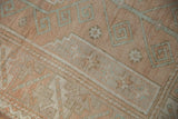 Texture of distressed Melas rug featuring geometric stepped patterns in terracotta, ivory, and seafoam.