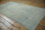 Distressed vintage Oushak runner texture highlighting faded blue-ivory geometric leaf pattern.