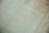 Seafoam green distressed Oushak rug texture, showing subtle ivory floral guls.