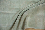 Folds of vintage distressed Oushak rug, showing worn pile texture and blended seafoam, ivory, beige tones.