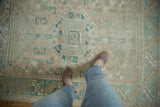 Distressed texture and geometric field design in beige and powder blue on a vintage Melas rug.