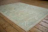 Distressed Melas rug's wide banded border with alternating faded blue geometric and floral designs.