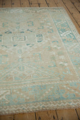 Distressed vintage Melas rug close-up, beige and powder blue geometric patterns, visible pile wear.