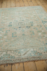 Distressed texture of a vintage Melas rug, featuring beige and powder blue geometric motifs and serrated leaves.