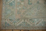 Vintage distressed Melas rug corner, beige and blue geometric border, visible wear.