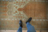 Distressed Oushak rug featuring copper and seafoam geometric and floral motifs.