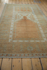 Distressed Oushak rug's wide geometric border with pale sea foam and terracotta motifs.