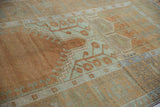 Distressed vintage Oushak rug with copper germinating plant and sea foam serrated leaf border.