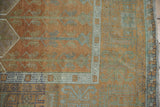 Vintage distressed Oushak rug corner with copper tones and wide geometric serrated leaf border.