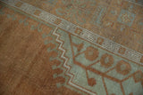Distressed copper and sea foam Oushak rug showing reciprocating running-t border detail.