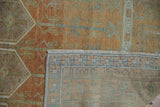 Distressed Oushak rug's hand-knotted reverse, revealing terracotta, blue, sea foam patterns.