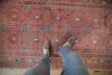 Textured vintage Oushak runner displaying faded raspberry and slate geometric patterns.