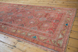 Distressed Oushak rug detail: soft raspberry field, hexagonal medallions, and rams horn border.
