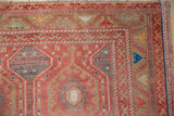 Distressed Oushak runner corner, serrated border and rams horn motif in dusty red.