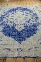 Vintage distressed Oushak rug, showing worn cobalt blue motifs and exposed knot heads.
