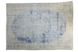 Decorative distressed Oushak carpet with faded cobalt blue floral medallion and ivory ground.