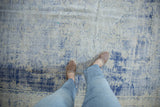 Vintage Distressed Oushak carpet with worn foundation and faded cobalt blue floral design.
