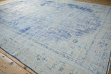 Faded cobalt blue floral patterns on ivory, visibly distressed vintage Oushak pile.