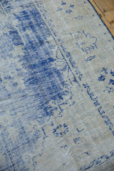 Distressed texture of a vintage Oushak rug in faded cobalt blue and light pile.