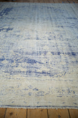 Vintage distressed Oushak carpet with worn pile exposing the blue and ivory foundation.