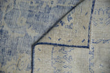 Curled corner of distressed Oushak rug, showing worn cobalt blue pile and hand-knotted foundation.
