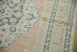 Distressed Oushak rug detail with pale apricot, dusty navy floral buds and meandering vines.
