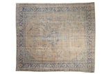 Vintage distressed Oushak carpet with a faded floral medallion in sandy beige and decorative cobalt blue accents.