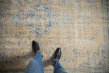 Overhead detail of a distressed Oushak carpet's low pile and visible wear in sand and cobalt blue.