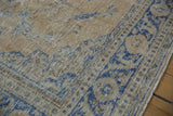 Worn, low-pile texture on the sand and cobalt blue corner of a vintage distressed Oushak rug.