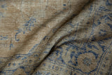 Worn pile and visible knot heads on a vintage Oushak in sand and cobalt blue hues.