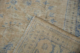 Close-up of a distressed Oushak corner highlighting the exposed knot heads and foundation weave.