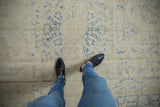 Vintage Oushak rug showing distressed ivory pile with faded cobalt blue florals.
