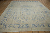 Distressed vintage Oushak rug with faded cobalt blue floral medallion and ivory tones.