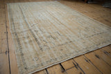 Vintage distressed Oushak rug in ivory with softened pile and faint traditional patterns.